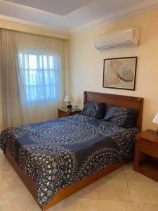 a bedroom with a bed with a blue comforter and a window at Delta sharm in Sharm El Sheikh