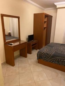 a bedroom with a bed and a desk and a mirror at Delta sharm in Sharm El Sheikh