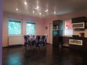a kitchen with a table and chairs in a room at Designed by love in Mikepércs