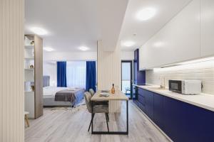 a kitchen and a bedroom with a bed and a table at Unique by UpTown Apartments in Iaşi