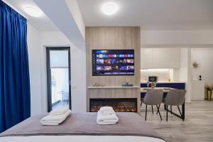 a bedroom with a bed and a tv above a fireplace at Unique by UpTown Apartments in Iaşi