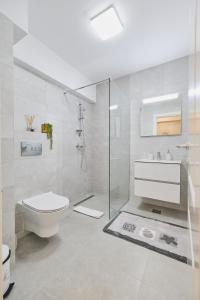 a white bathroom with a toilet and a sink at Unique by UpTown Apartments in Iaşi +39 photos