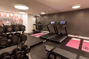 a gym with several tread machines and a mirror at Quirk Hotel Richmond in Richmond