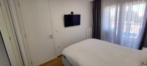 a small bedroom with a bed and a window at Extra Apartman Palata in Banja Luka