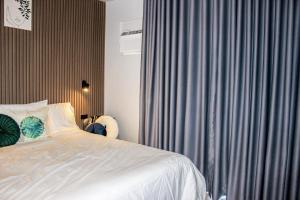 a bedroom with a white bed and a gray curtain at Nap Trap in Cebu City +19 photos