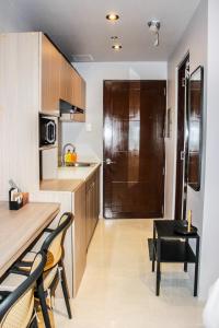 a kitchen with wooden cabinets and a table and chairs at Nap Trap in Cebu City