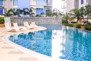 a swimming pool at a resort with white chairs and a building at Nap Trap in Cebu City