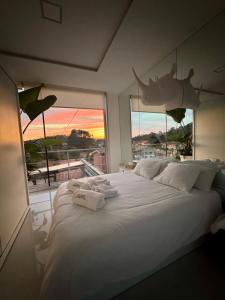 a bedroom with a large white bed with a large window at Apartamento Cubo de Cristal con piscina y vistas al mar in O Grove