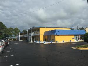 um grande edifício amarelo com estacionamento em Belmont Inn and Suites em Hampton