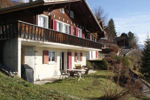 a house with a table and chairs in front of it at Abigrot in Hasliberg Wasserwendi