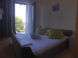 a bed with pillows on it in a room with a window at Guesthouse Villa Manda in Lovran