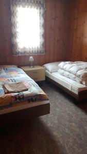 two beds sitting in a room with a window at Ferienwohnung Ritz in Ernen