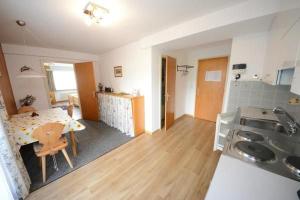 a kitchen and a dining room with a table and a kitchen at Chesa Talvo in Samedan