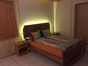 a bedroom with a large bed with a light on it at Haus Am See in Därligen +3 photos