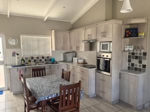 a kitchen with a table and a table and chairs at The Pearl in Pearly Beach