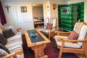 a living room with wooden furniture and green walls at Ferienhaus Wühre in Appenzell +29 photos