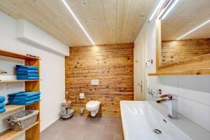 a bathroom with wooden walls and a toilet and a sink at Bauernhof Fendrig Neue Wohnung in Haslen