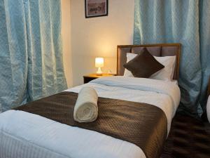 a bedroom with a large bed with blue curtains at Kurambik Eco Homestay in Dumkhar
