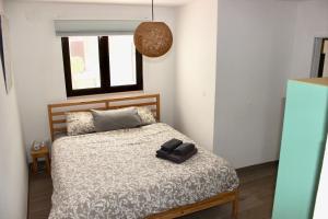 a bedroom with a bed with a pair of shoes on it at Vivenda Montanha - Relax in Nature in Alcaria