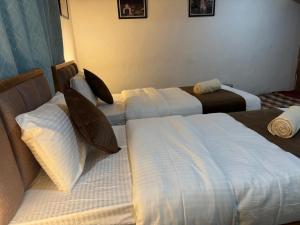 a hotel room with two beds with white sheets at Kurambik Eco Homestay in Dumkhar