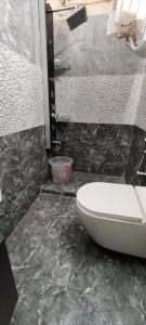 uma casa de banho com um WC branco e uma parede preta em Charming Chennai Home with Modern Amenities em Chennai