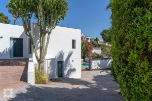 a white house with a palm tree in front of it at Villa Chic Romance by Abahana Villas in Fanadix