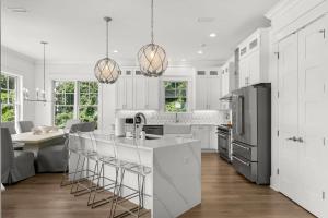 a kitchen with white cabinets and a black refrigerator at Paradiso Del Mare by Stay on 30A, Gulf View- Private Pool! in Inlet Beach
