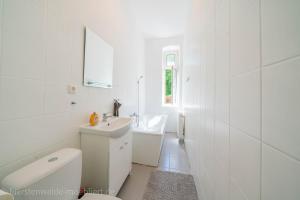 a white bathroom with a sink and a toilet at Apt Watt 2 Zimmer 55qm TV Waschmaschine Trockner Vollausstattung zentral in Fürstenwalde