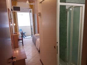 a room with a bedroom and a bathroom with a glass door at Hotel Augusta in Gabicce Mare +55 photos