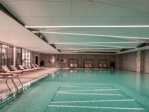 a large swimming pool with chairs and a pool at Crowne Plaza Hangzhou Science City by IHG in Hangzhou