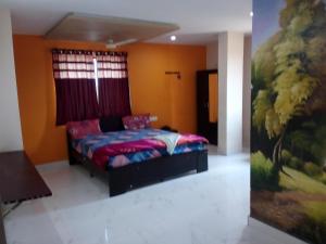 a bedroom with a bed with a painting on the wall at lotuspond resort and spa in Jāmb
