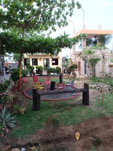 a garden with chairs and a bench in front of a house at lotuspond resort and spa in Jāmb