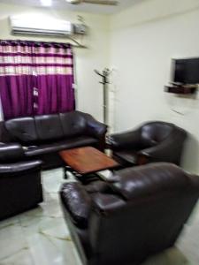 a living room with two leather chairs and a table at lotuspond resort and spa in Jāmb