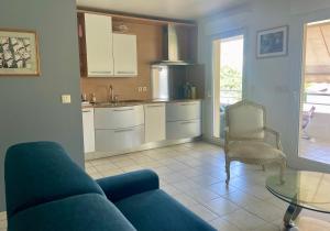 a living room with a blue couch and a kitchen at Prince de Galles in Cannes