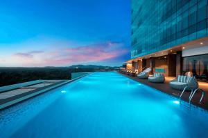 a swimming pool in the middle of a building at Private Apartment Wyndham Panbil with Gym & Pool in Kangboi