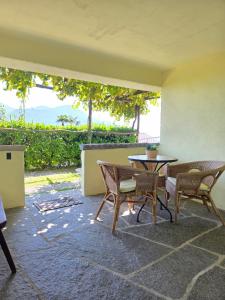 a patio with a table and chairs on a patio at Casa Leyian - Brissago in Brissago