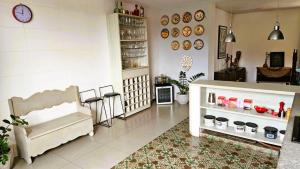 a living room filled with furniture and a clock on the wall at Quarto expetacular in Timóteo