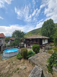 a backyard with a house and a swimming pool at Къща за гости Хитър Петър in Apriltsi