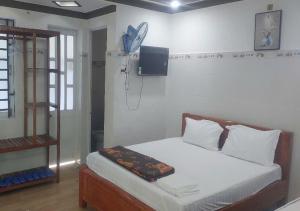 a bedroom with a bed with a tv on the wall at Biển Ngọc Homestay - Ngay sát biển Phan Rang in Bắc Sớn