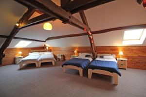 a bedroom with four beds in a room with wooden walls at Fonbanoux in Flavignac