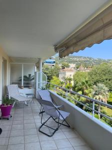 a balcony with chairs and a view of the city at Prince de Galles in Cannes