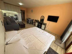 a bedroom with a large bed and a living room at Panorama Vigo Studio in Nesebar