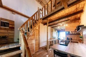 a kitchen and dining room with wooden walls and wooden stairs at Zalaidill Wellness Vendégház in Nagybakónak