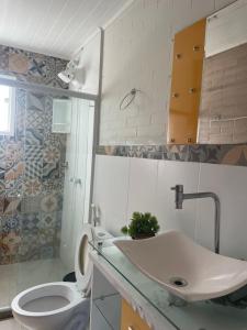 une salle de bain avec des toilettes blanches et un lavabo dans l'établissement Casa con vista al mar, à Búzios