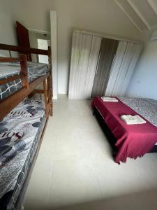 une chambre avec deux lits superposés et une couverture rouge dans l'établissement Casa con vista al mar, à Búzios