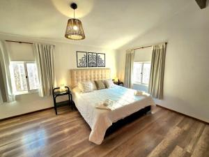 Un dormitorio con una cama y dos ventanas. en La Margarita Lofts, en Mina Clavero 23 fotos más