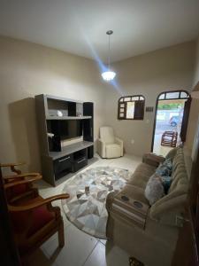 salon z kanapą i telewizorem w obiekcie Temporada CG - Casa Jardim Quarenta w mieście Campina Grande