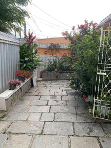 kamienny chodnik w ogrodzie z roślinami i kwiatami w obiekcie Temporada CG - Casa Jardim Quarenta w mieście Campina Grande