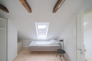 a bedroom with white walls and a bed with a window at 4-BR apartment with a balcony in Hellerup - 182 in Hellerup