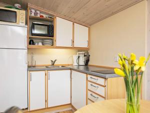 Una cocina con gabinetes blancos y un refrigerador blanco. en 2 person holiday home in Otterup, en Otterup